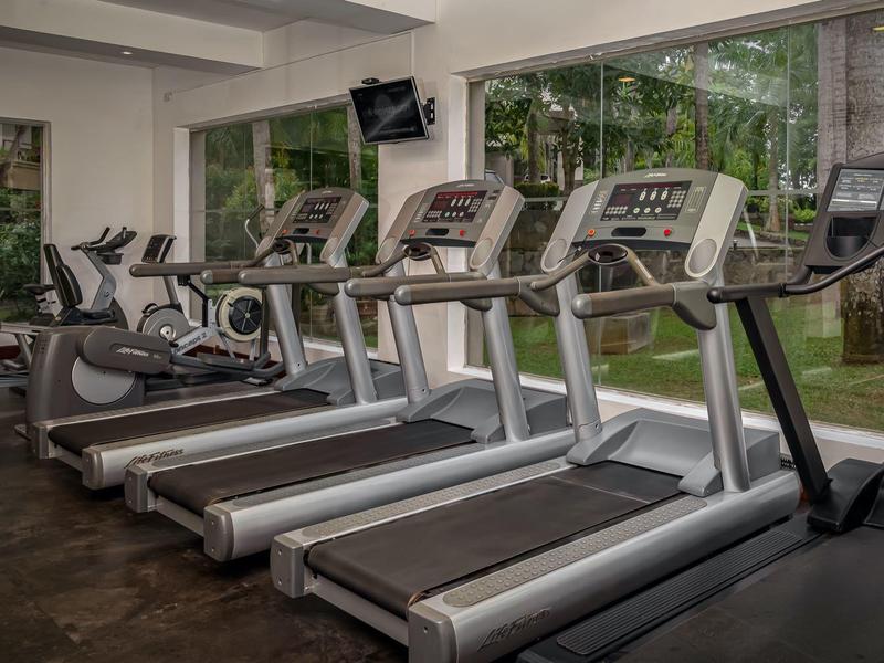 Sportschool met meerdere loopbanden en apparatuur voor grote ramen.