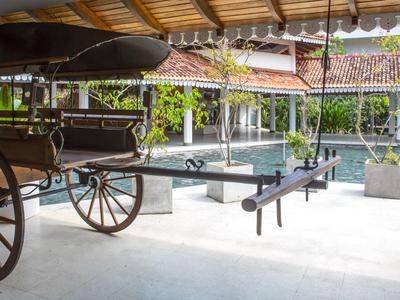 Tradiční dřevěný povoz pod zastřešením vedle bazénu v hotelu.