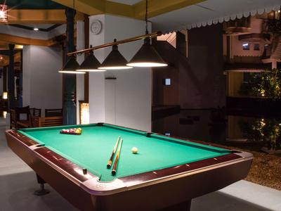 Billardtisch in einem modern beleuchteten Innenbereich mit dekorativen Lampen darüber.