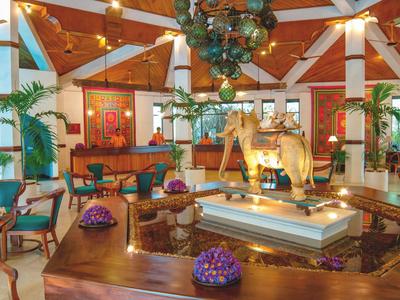 Großer Hotellobby mit Holzdecke, Kunstwerken und zentraler Skulptur eines Elefanten.