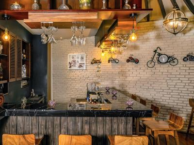 Gemütliche Bar mit rustikalem Holzdesign, hängenden Gläsern und Wanddekorationen aus Metallmotorrädern.