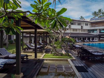 Moderner Außenpoolbereich mit Liegestühlen und überdachten Sitzbereichen in einem Resort