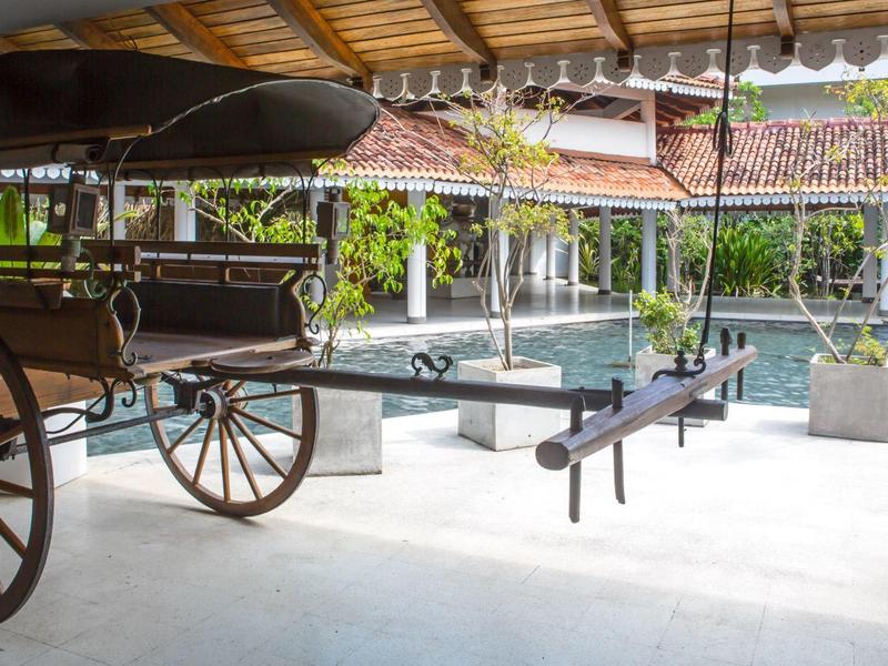 Tradiční dřevěný povoz pod zastřešením vedle bazénu v hotelu.