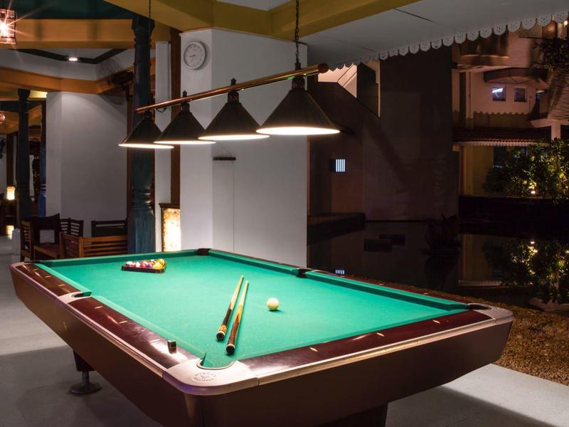 Osvětlený kulečníkový stůl v moderním salónku s útulnou noční atmosférou.