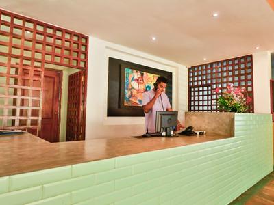 Moderner Empfangsbereich mit hellem Tresen, Rasterwänden und einem Gemälde an der Wand.