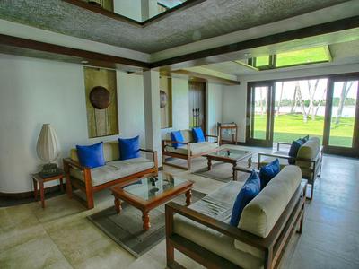 Moderner Loungebereich in Hotel mit Holzmöbeln und blauen Kissen, Blick auf Garten