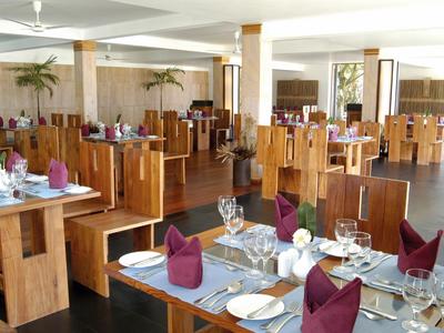 Heller Hotel-Loungebereich mit bunten Sitzmöbeln und Tischen auf dunklem Holzboden