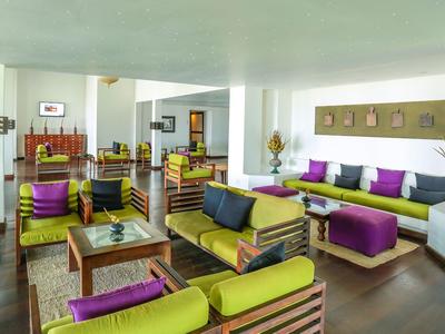 Heller Hotel-Loungebereich mit bunten Sitzmöbeln und Tischen auf dunklem Holzboden