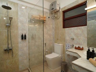 Modernes Badezimmer mit begehbarer Dusche, Toilette und Waschtisch in einem Hotelzimmer.