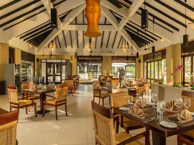 Bright, inviting restaurant with wooden tables and chairs, large windows, and ceiling fans.