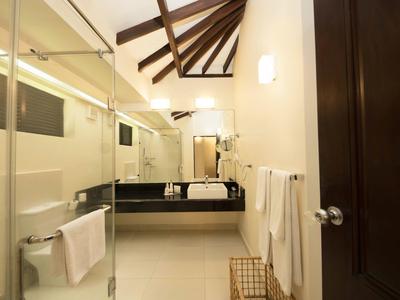 Modern bathroom with glass shower, wooden beam ceiling, and black sink countertop.