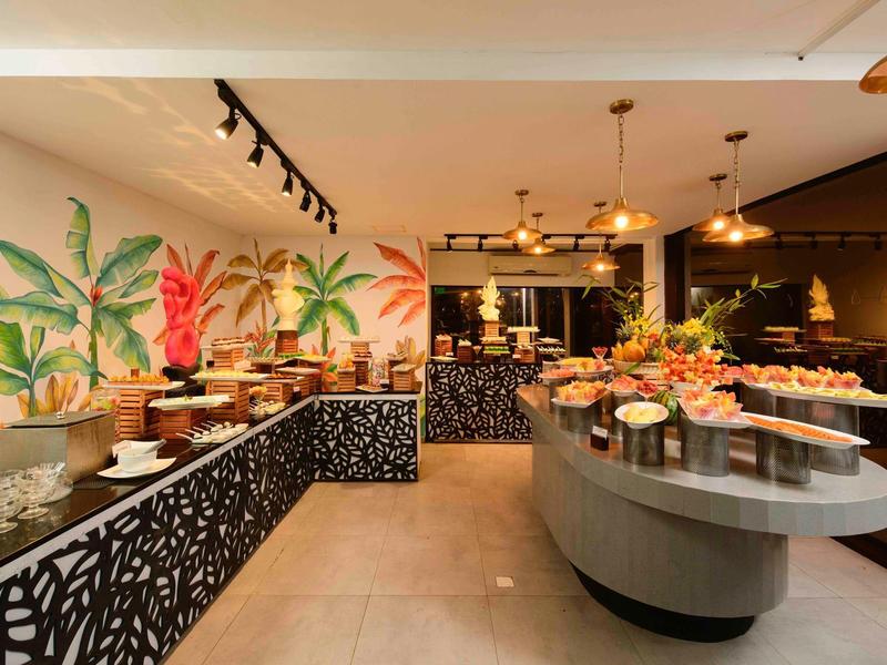 Modern buffet with tropical wall design and decorative lighting in the restaurant.
