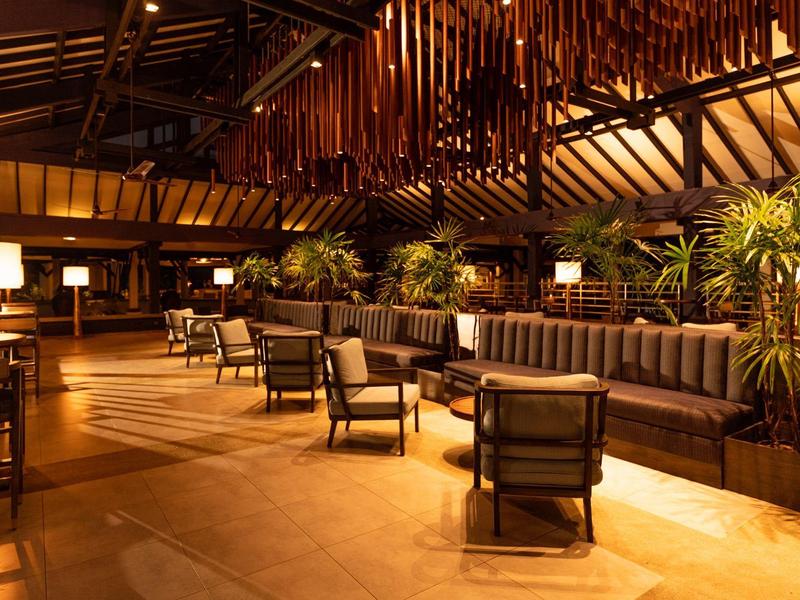 Cozy hotel lounge with multiple seating areas and warm lighting.