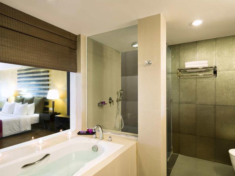 Moderne badkamer met whirlpool en aparte inloopdouche in hotelkamer.