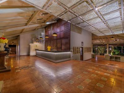 Großer Empfangsbereich mit Holz- und Steinakzenten, warm beleuchtet, in einem Hotel.