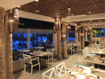 Restaurant moderne avec accents en bois et éclairage d'ambiance au crépuscule.