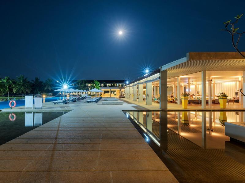 Moderne hotelomgeving met verlicht zwembad en vollemaanacht