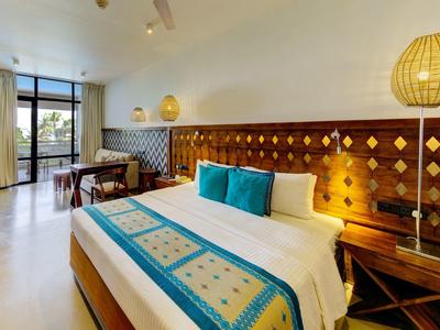 Nowoczesny pokój hotelowy z dużym łóżkiem i balkonem z widokiem.