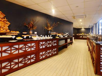 Strefa bufetu z różnorodnym jedzeniem w jasnej, nowoczesnej restauracji.