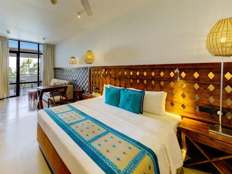 Nowoczesny pokój hotelowy z dużym łóżkiem i balkonem z widokiem.