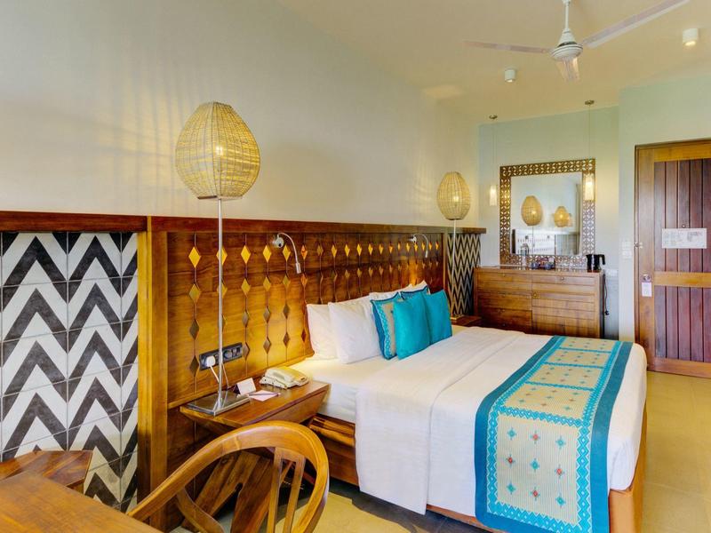 Nowoczesny pokój hotelowy z łóżkiem podwójnym i kolorową dekoracją.