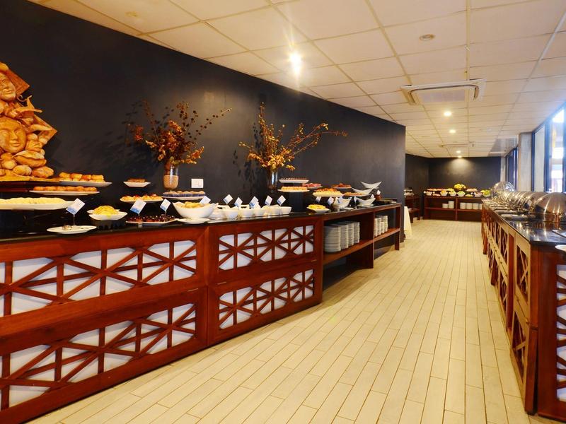 Strefa bufetu z różnorodnym jedzeniem w jasnej, nowoczesnej restauracji.