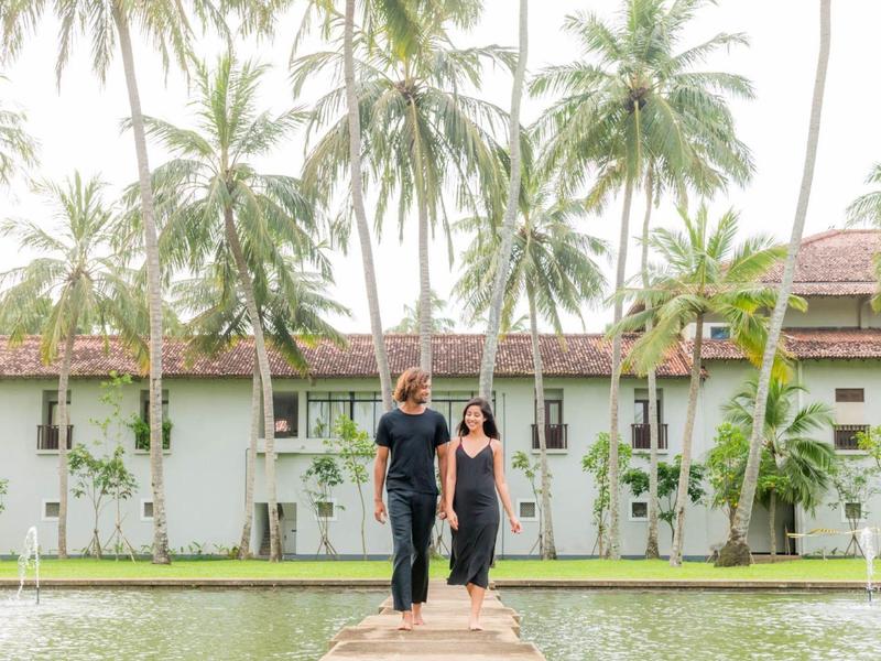 Stel op een steiger voor tropisch hotel met palmbomen en water