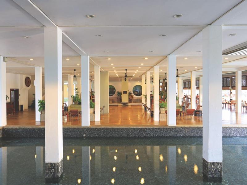 Hotelinterieur met zuilen en een waterpartij, met een modern en helder ontwerp.