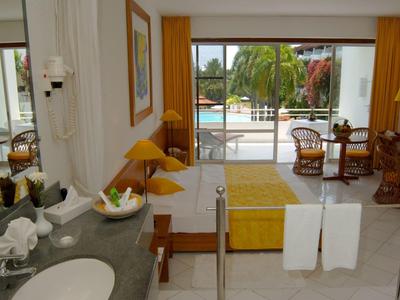 Modern hotel room area with yellow accents and view of outdoor pool.