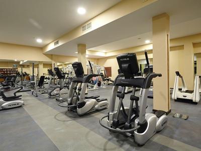 Innenraum eines Fitnessstudios mit verschiedenen Trainingsgeräten in einem Hotel.