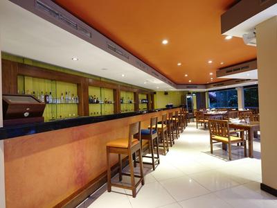 Barová část s židličkami a stoly v moderní hotelové restauraci.