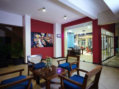 Pohodlný vnitřní prostor s dřevěným nábytkem, modrými polštáři a moderním uměním na zdi.