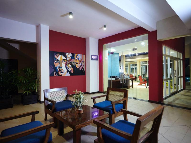 Pohodlný vnitřní prostor s dřevěným nábytkem, modrými polštáři a moderním uměním na zdi.