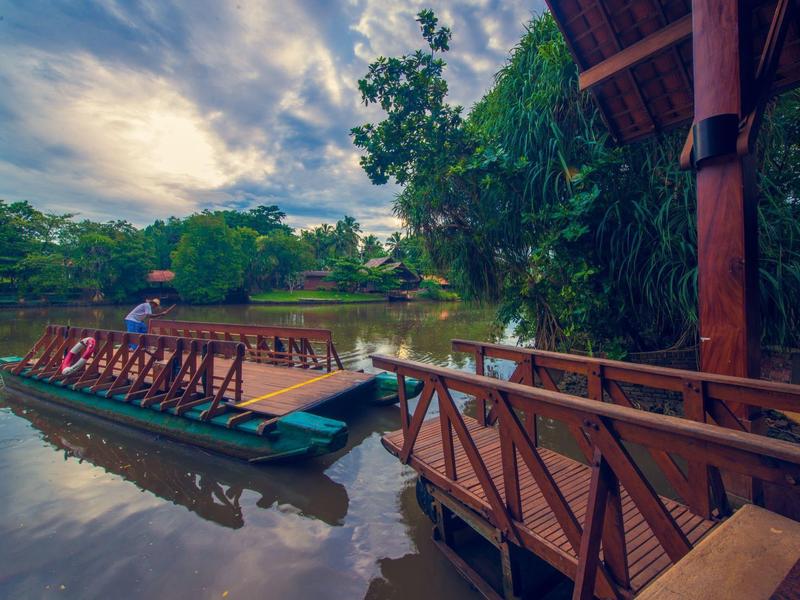 Houten steiger met bootsteiger aan kalm meer omgeven door weelderig groen.