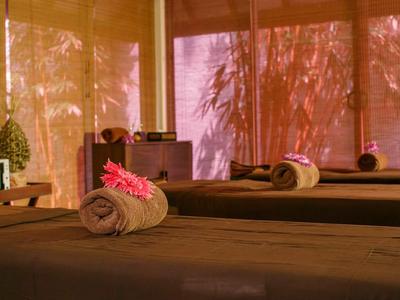 Acogedora sala de spa con camas de masaje marrones y luz cálida.
