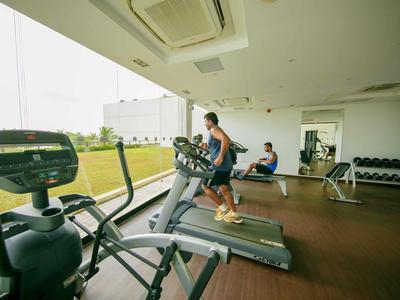 Gimnasio moderno con caminadora y amplia vista a un área verde exterior.