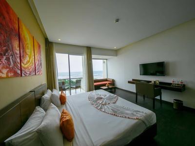 Habitación de hotel moderna con cama grande, balcón y vista al mar.