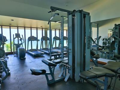 Attrezzature da palestra moderne in una palestra ben illuminata con grandi finestre.