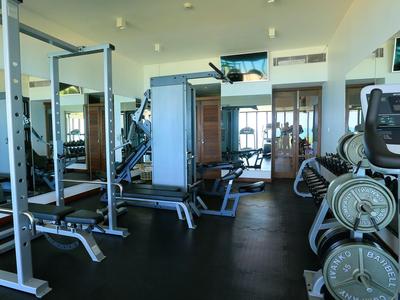 Vista interna di una palestra con attrezzi e specchi in un hotel.