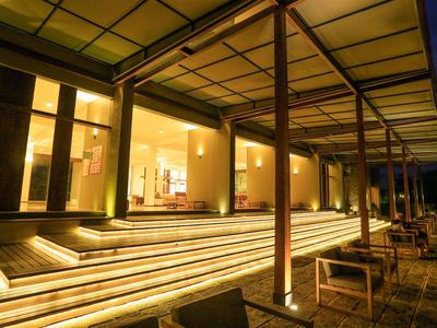 Area esterna illuminata con scale e mobili lounge di notte in un hotel.