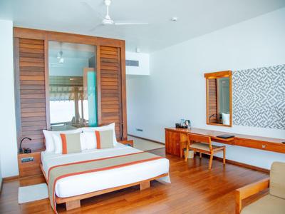 Camera d'hotel moderna con letto matrimoniale, pavimento in legno, scrivania e televisore.