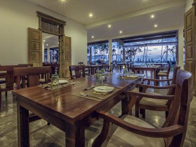 Gezellig restaurant met houten meubels en uitzicht op een terras bij zonsondergang.