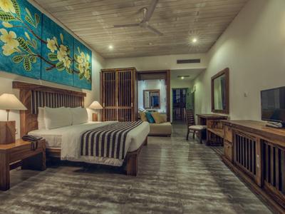 Modern hotelkamer met groot bed, houten decor en kunstzinnige muurschildering.