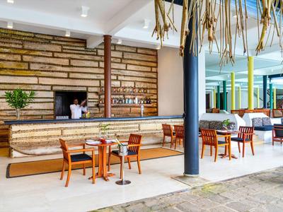 Moderner Hotelbarbereich mit Holztheke und mehreren Stühlen in hellem Raum