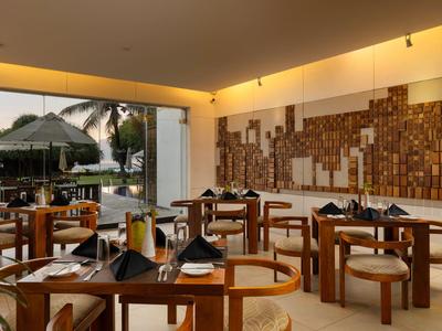 Ristorante moderno con decorazioni in legno, tavoli di legno e vista sulla piscina esterna.