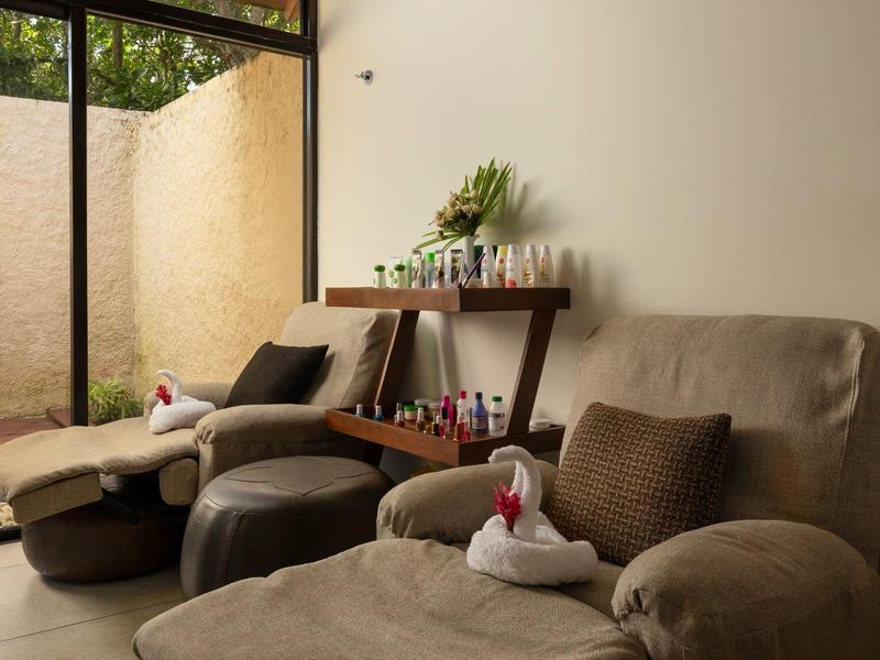 Zona relax accogliente con poltrone comode, sgabelli e asciugamani per massaggi in un ambiente tranquillo.