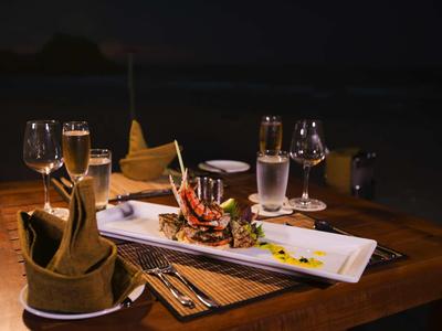 Romantyczna kolacja z winem i wykwintnym daniem na drewnianym stole w nocy.