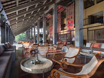 Offene Lounge mit Holzmöbeln, Tischen und gemütlicher Atmosphäre in einem Hotel.