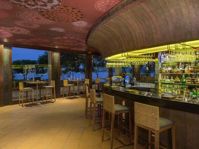 Moderne Bar mit Hockern und stimmungsvoller Beleuchtung in einem Hotel