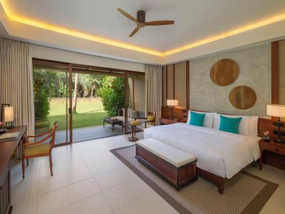 Modernes Hotelzimmer mit Doppelbett und Blick auf einen Garten.